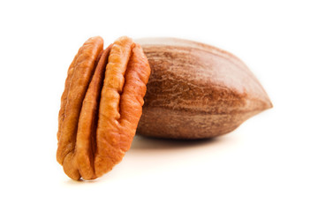 Not cleaned pecan nuts in the shell isolated on white.