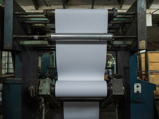 Fototapeta na wymiar Printing of the newspaper on the old equipment. Printing shop of printing house