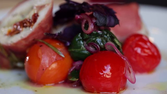 A bright dish of vegetables with meat on a plate that revolves around its axis. Tomatoes with meat restaurant food