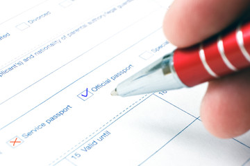 Schengen visa, questionnaire. Hand with pen completing a questionary.