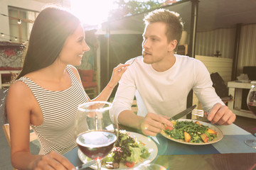 Cheerful dark-haired girl in striped sleeveless t-shirt putting food