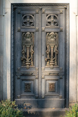 Fototapeta na wymiar Mit Engeln und den Worten Frieden und Ruhe verzierte antike Tür auf dem Dorotheenstädtischen Friedhof in Berlin