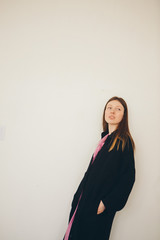 Naklejka premium beautiful girl in long linen coat on white background. Model in advertising clothing