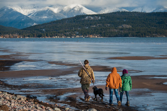 Rear view of family with dog walking near Flathead Lake in Montana