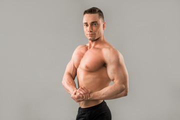 handsome man with muscles on gray background