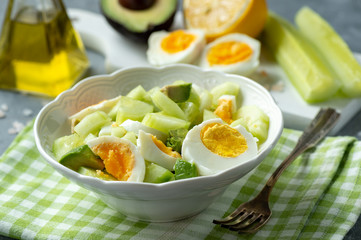 Healthy vegetarian salad with avocado, eggs and cucumbers.