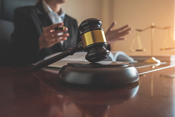 Justice and Law concept. Legal counsel presents to the client a signed contract with gavel and...