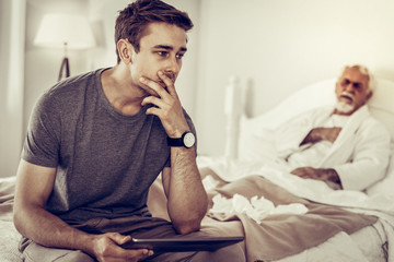 Worried man thinking of the illness of his aging father
