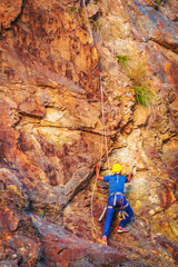 Young man looking up while climbing challenging route on cliff in Rishikesh India - Image