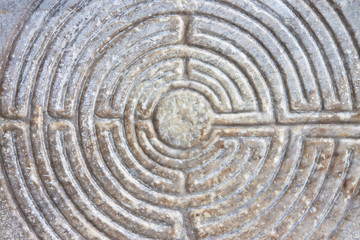 Fototapeta na wymiar Labyrinth carved on the stone facade of a Romanesque church of the 11th century (Tuscany - Italy)