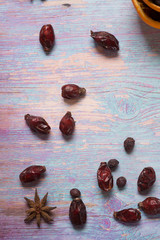blue wooden background with cinnamon, anise and dog rose