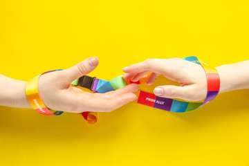 LGBT symbol - wo women's hands wrapped in rainbow ribbon stretch one to one, the concept of the difficulty of same-sex love and separation