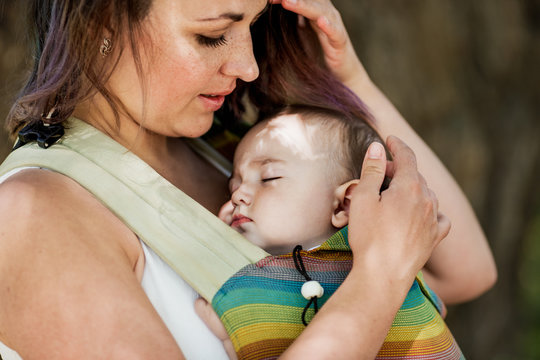 Informal Mother Carry Baby Girl In Baby Carrier In Park