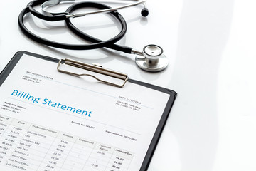 medical treatment bill and phonendoscope on white background