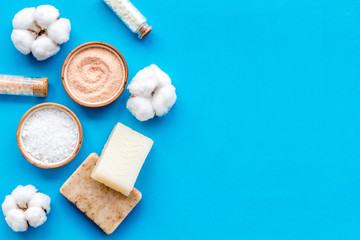 Zero waste set with cosmetics for spa and cotton materials on blue background top view copyspace