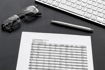 business accounter work with taxes calculation, keyboard and glasses on black office desk background