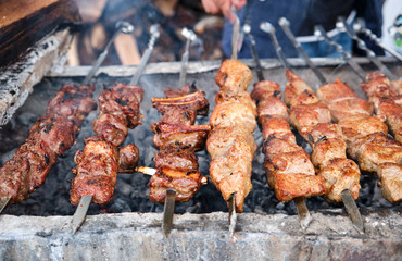 Grilled kebab cooking on metal skewer. Roasted meat cooked at barbecue. BBQ fresh beef meat chop slices. Traditional eastern dish, shish kebab.