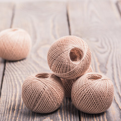 Balls of yarn thread for knitting on a wooden background.