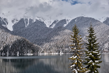 Beautiful mountain Lake Ritsa. Lake Ritsa in the Caucasus Mountains, in the north-western part of Abkhazia, Georgia, surrounded by mixed mountain forests and subalpine meadows. Snow in mountains
