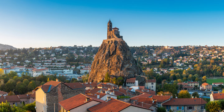 View of Saint Michel d'Aiguilhe chapel on rock surrounded by cityscape
