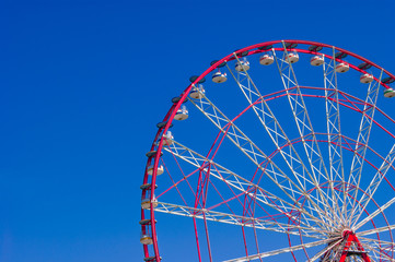 Quarter Ferris wheels with deep blue sky in the background