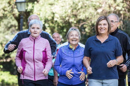 Anziani signori fanno attivit&agrave; di Jogging in mezzo ad un parco 