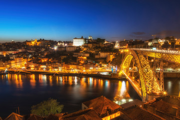 Night view of the Porto city center and Douro River with the bridge. Porto, Portugal.