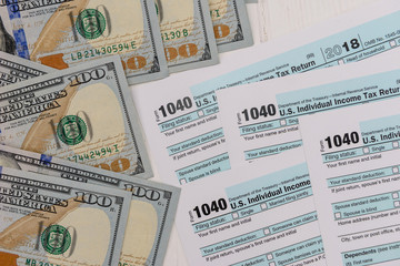 Fototapeta na wymiar 1040 tax form with american dollar banknotes close up