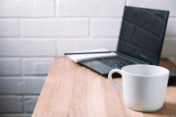 Fototapeta na wymiar White mug on wooden desktop. Template for text or design. Home office concept