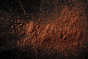 Fototapeta na wymiar Pile cocoa powder isolated on black background, top view