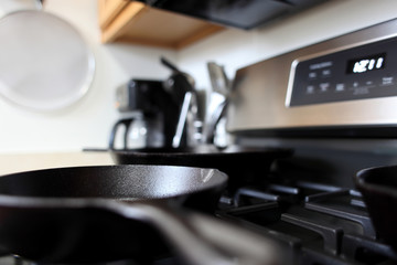 Fototapeta na wymiar Modern stainless steel gas stove with cast iron skillets in a home kitchen.
