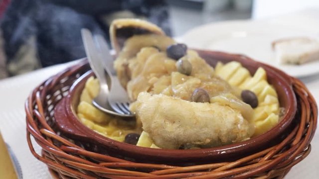 cod fish with onion and potato in ceramic dish