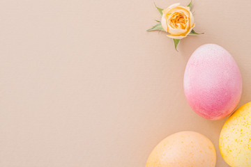 Easter eggs and a small rose on texture paper