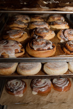 Delicious Freshly Baked Cinnamon Rolls with Sweet Icing on Trays