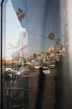 City Street Reflection with Palm Trees, Traffic, and Person Silhouette Aman, 