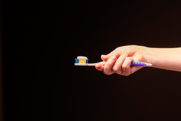 woman squeezes toothpaste on a brush