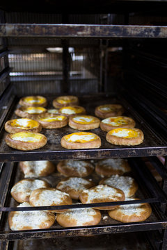 Freshly Baked Artisanal Pastries and Buns on Trays in a Commercial Bakery