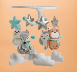 Colorful and eco-friendly children's mobile from felt. On light brown background.