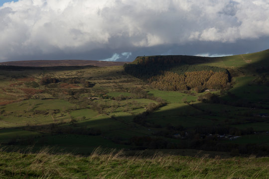 Scenic Moorland Valley with Dramatic Sky and Patchy Sunlight
