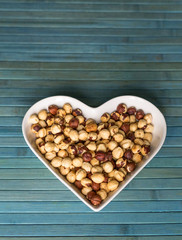 Nuts arranged in heart  on background. Healthy Food image close up hazelnuts. Love Texture on top view