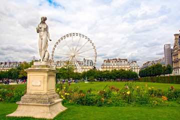 Marble statue and ferris wheel at Garden of Tuileries (Jardin des Tuileries) outside the Louvre in...