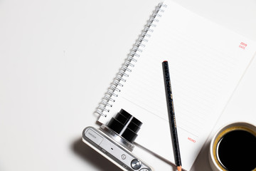 camera with blank spiral notebook on Flat lay