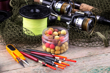 fishing tackle on a wooden table. toned image 