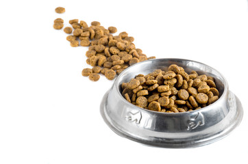 Scattered dry pet - dog food in metal bowl on white background