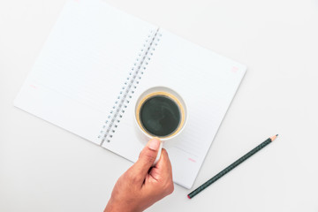 Woman hand holding cup of coffee open notebook Flat lay