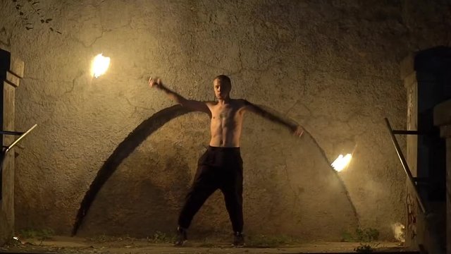Slow Motion Male Artist Of The Spins Fire Poi On A Rock