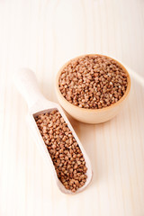 Buckwheat in a wooden bowl and  in wooden scoop for spices
