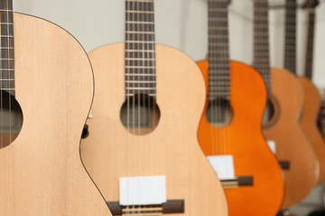 Fototapeta na wymiar Modern wooden guitars in music store, closeup