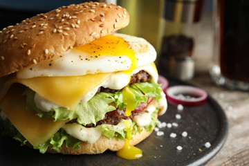 Tasty burger with fried egg on tray against blurred background, space for text