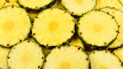 Pineapple juicy yellow slices background. Top view.